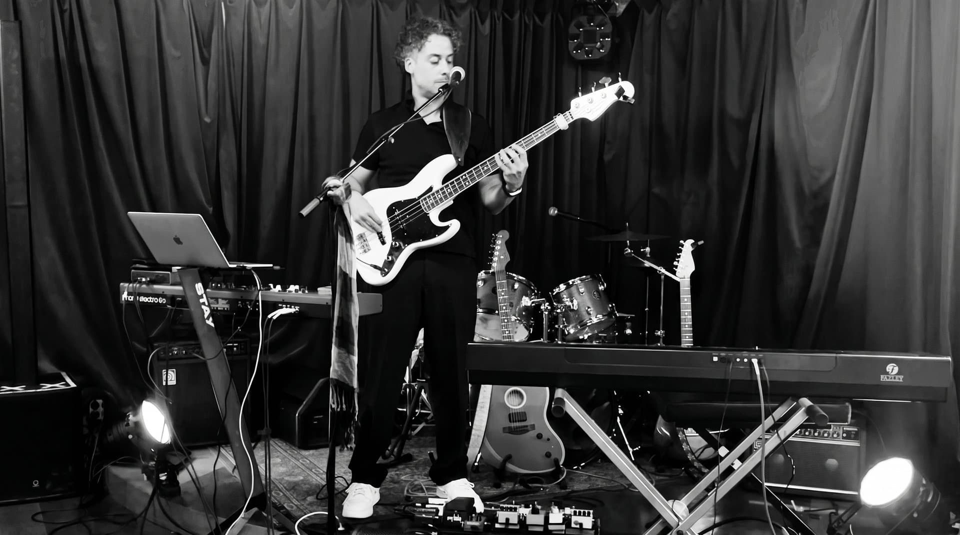 Osman Meyredi on stage surrounded by his instruments, black and white