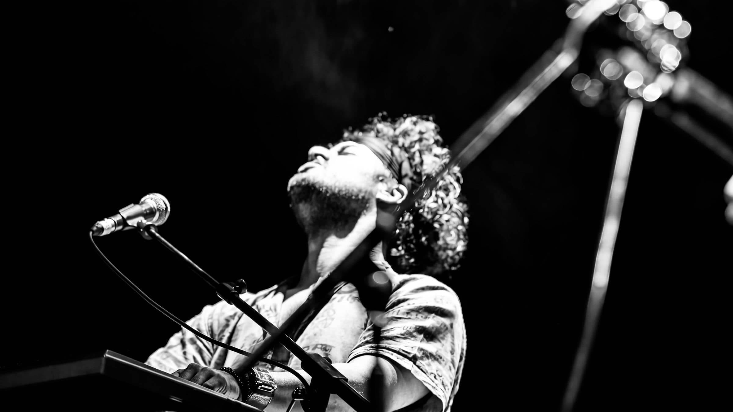Osman Meyredi mid-performance at the keys, black and white, head tilted back