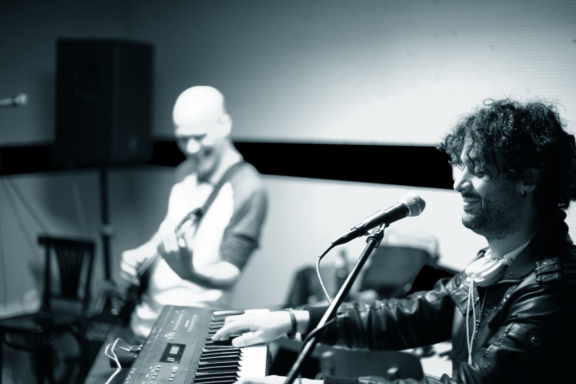Osman Meyredi at the keys in rehearsal with a guitarist, black and white