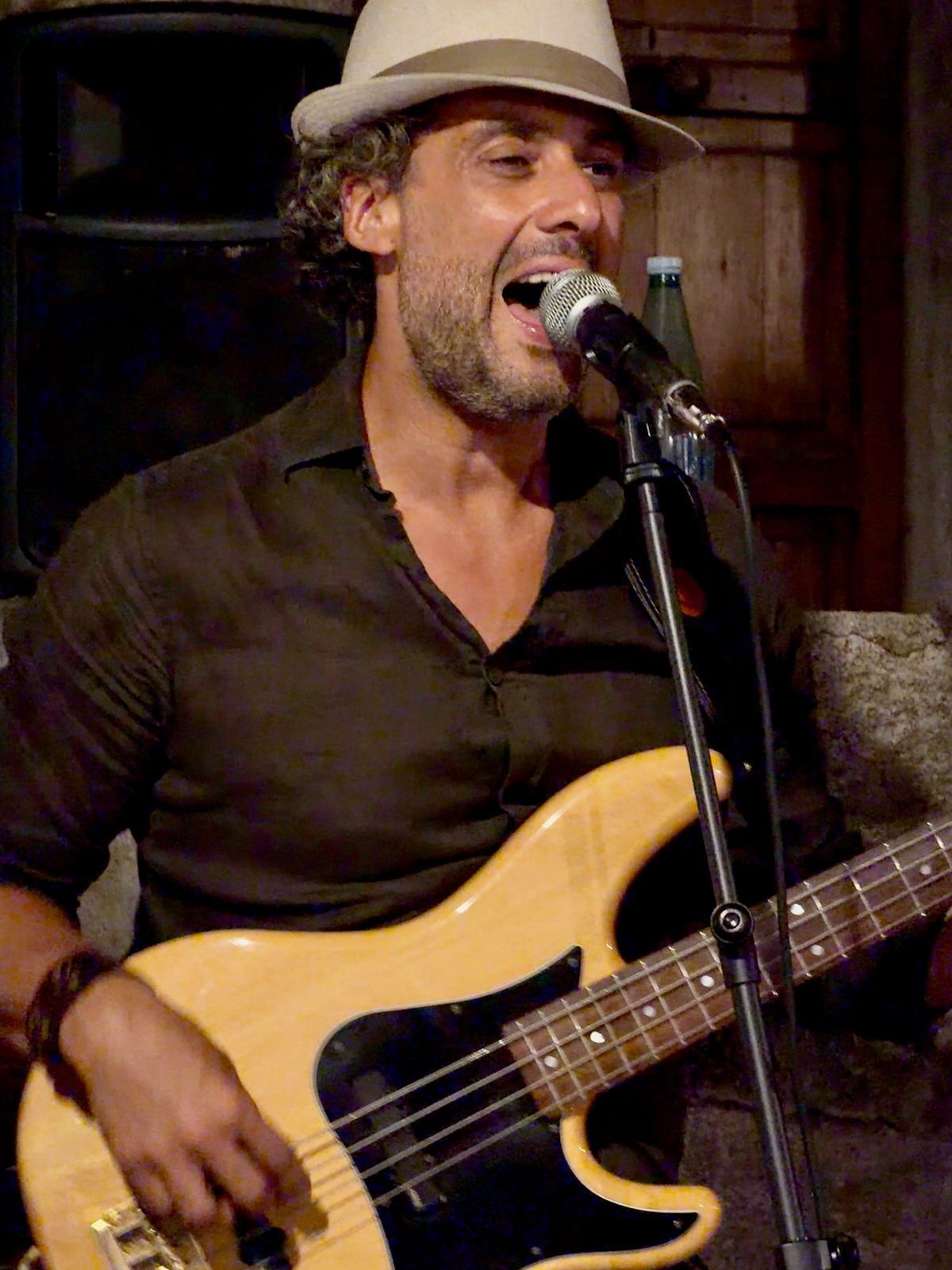 Osman Meyredi in a straw hat singing at the microphone