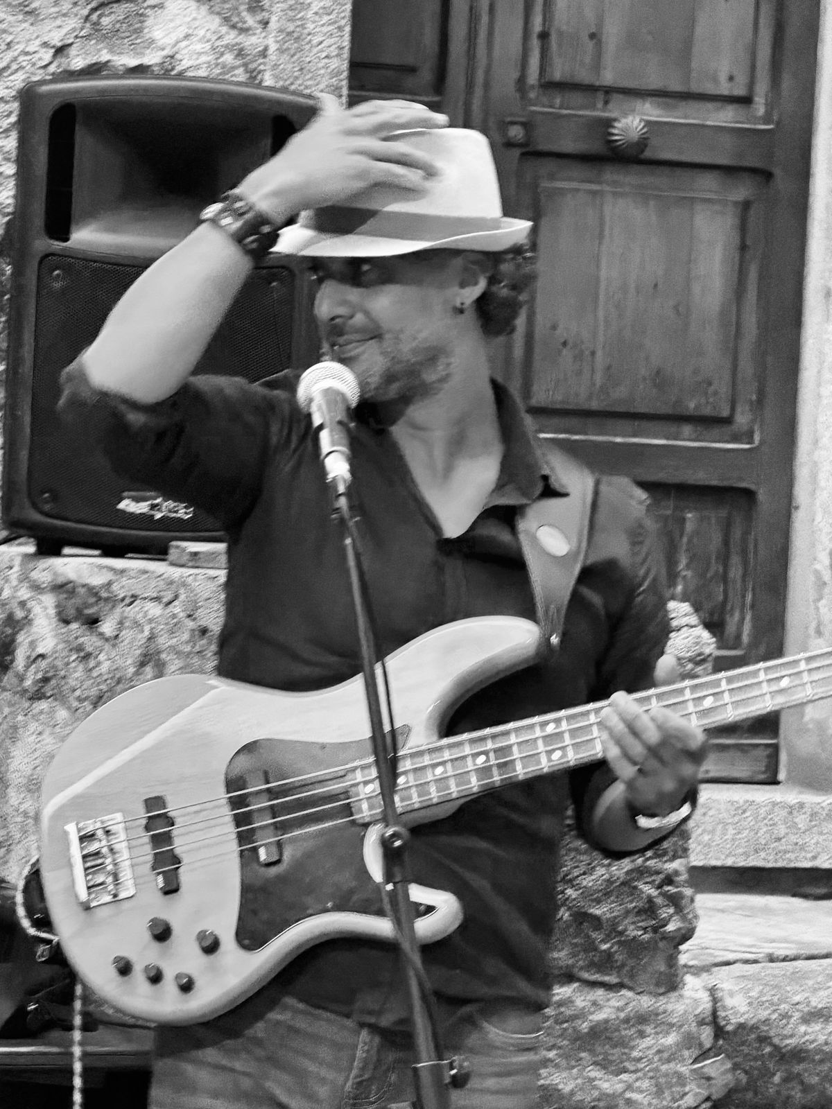 Osman Meyredi with his bass at an outdoor show in Italy, black and white